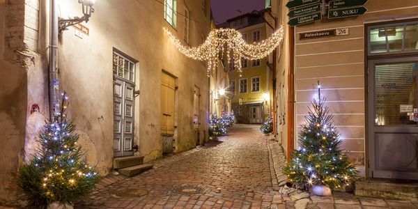 Altstadtgasse mit Lichterketten und kleinen Weihnachtsbäumen